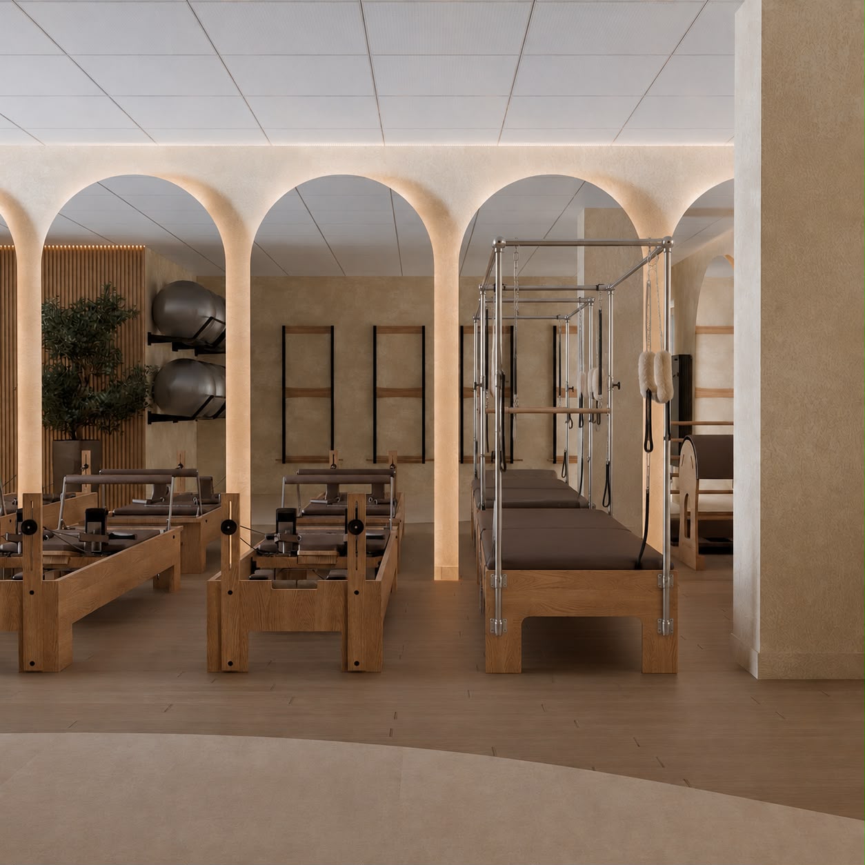 Sala de pilates com arcos iluminados e aparelhos em madeira